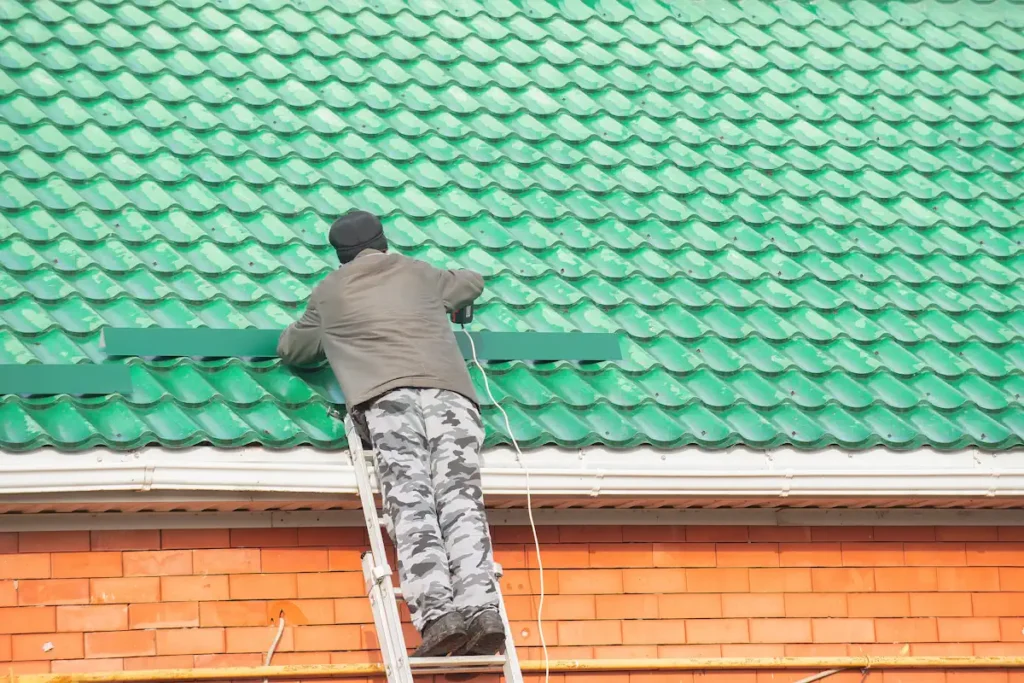 Un homme travaillant sur une toiture de maison verte