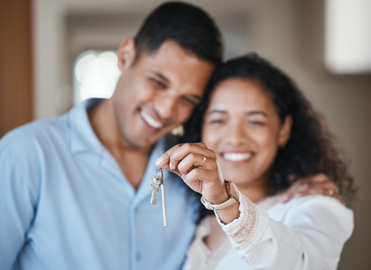 Un couple qui regarde des clefs avec le sourire 