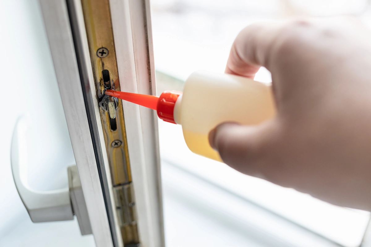 Une personne qui lubrifie une serrure de porte