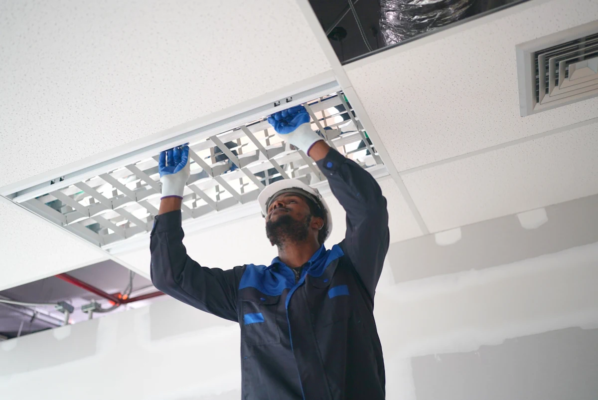 Un homme qui installe un faux plafond suspendu
