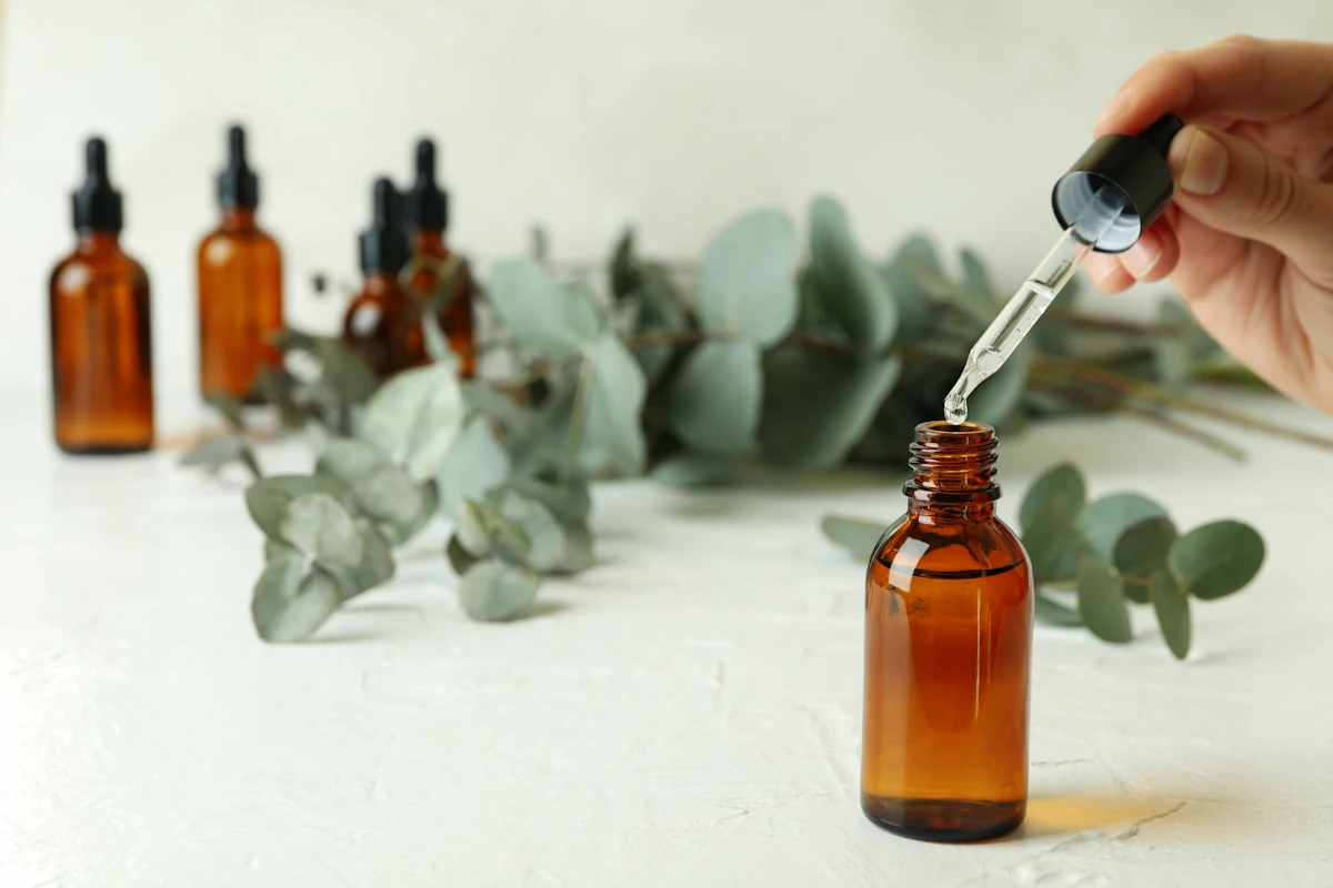 Une personne qui prend une pipette d''huile essentielle d'eucalyptus