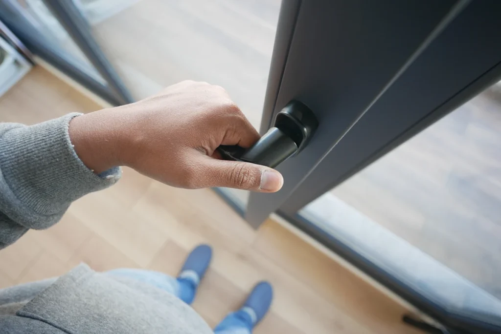 Une personne qui ouvre une porte qui frotte au sol