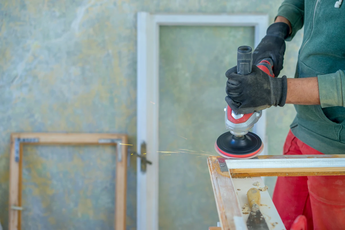 Une personne qui ponce une porte en bois