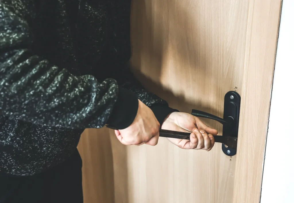 Une personne qui essaie d'ouvrir une porte qui s'est fermée toute seule