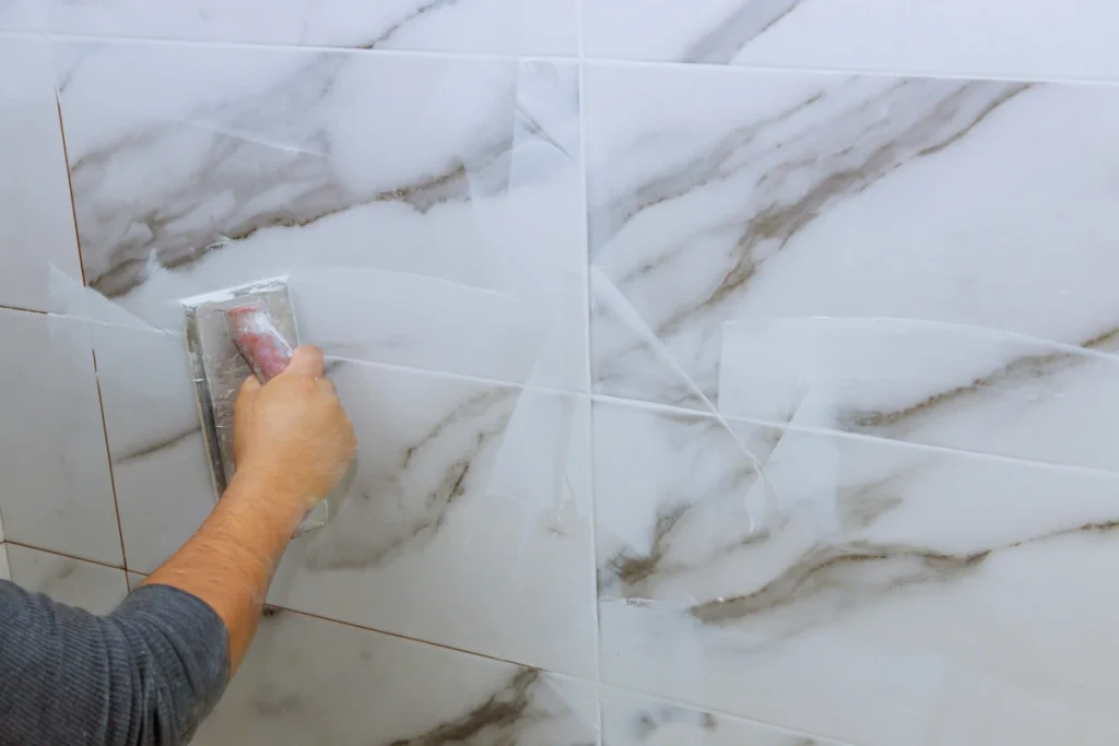 Une personne qui refait les joints de la salle de bain