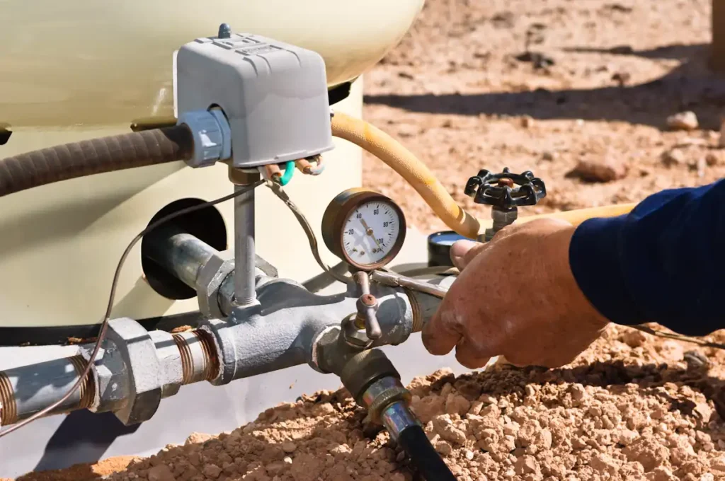 Une personne qui règle la pression d'un arrosage automatique