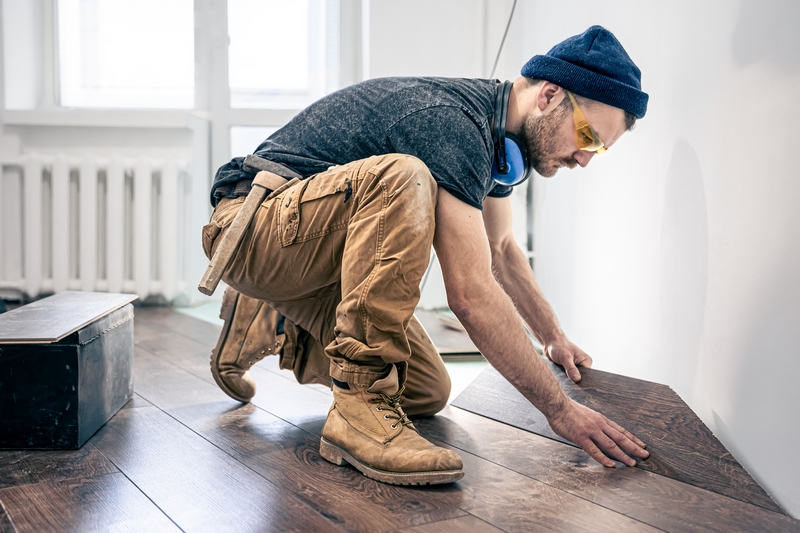homme qui pose un parquet flottant