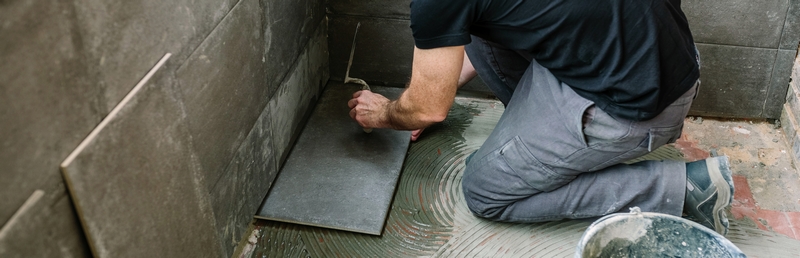 homme qui pose du carrelage avec des joints