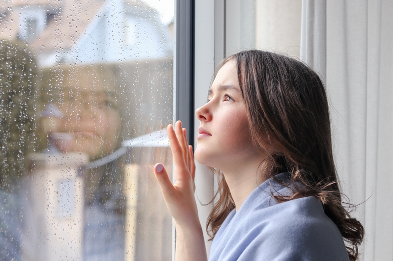 femme qui voit l'humidité sur les fenêtres