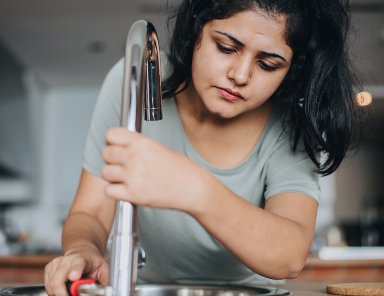 femme qui répare un robinet